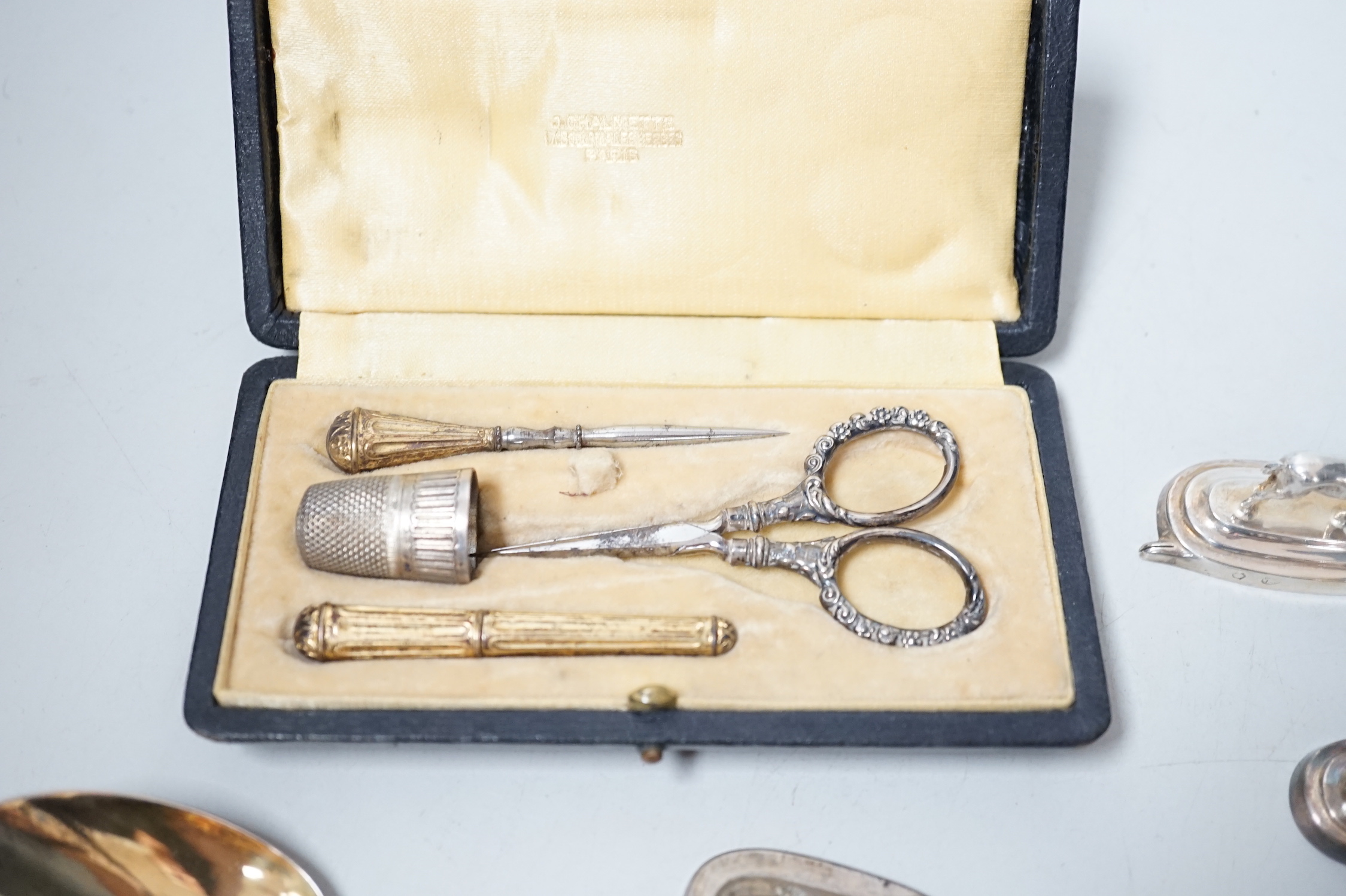 Six assorted Spanish white metal horse menu holders, 43mm, a cased necessaire set, a cigar cutter and a French white metal spoon with hand terminal.